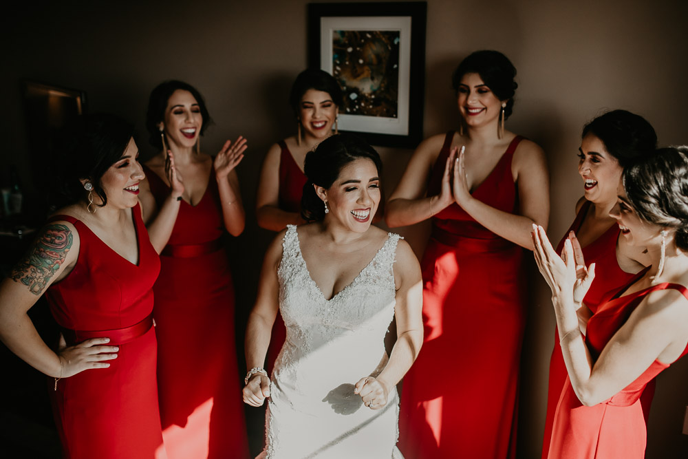 bridesmaids in red dresses laughing 