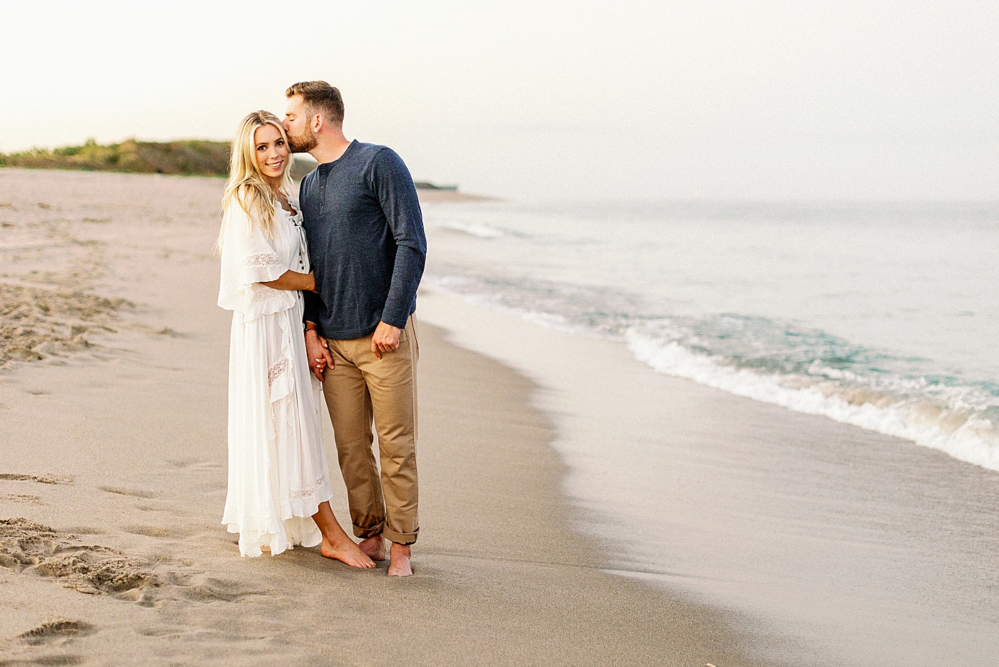 Man kisses woman on the beach Jupiter Engagement Photography captured by South Florida Engagement Photographer Erika Tuesta Photography