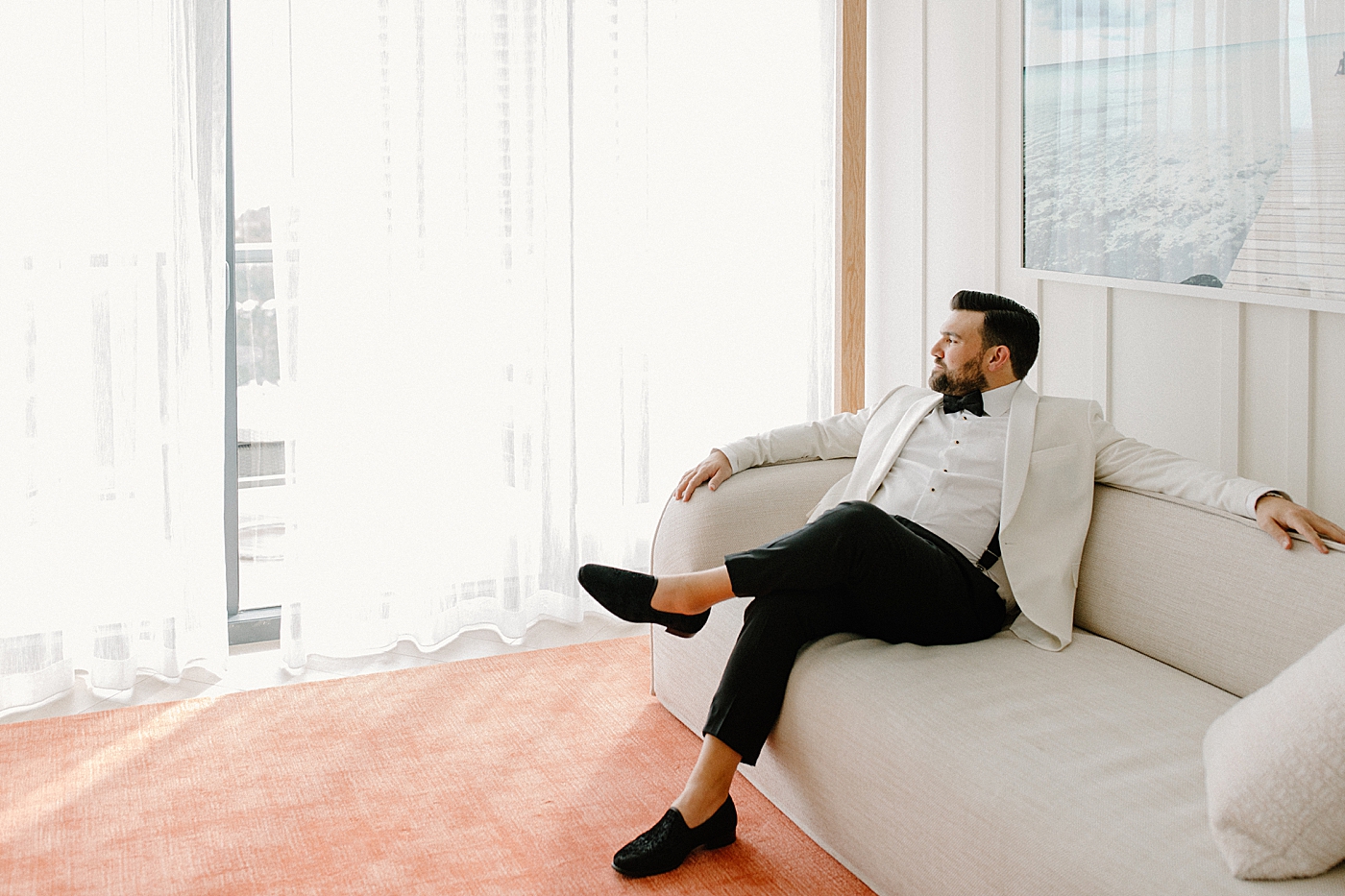 Groom sitting on couch after getting ready Modern Elegant Wedding at The W South Beach captured by South Florida Wedding Photographer Erika Tuesta Photography