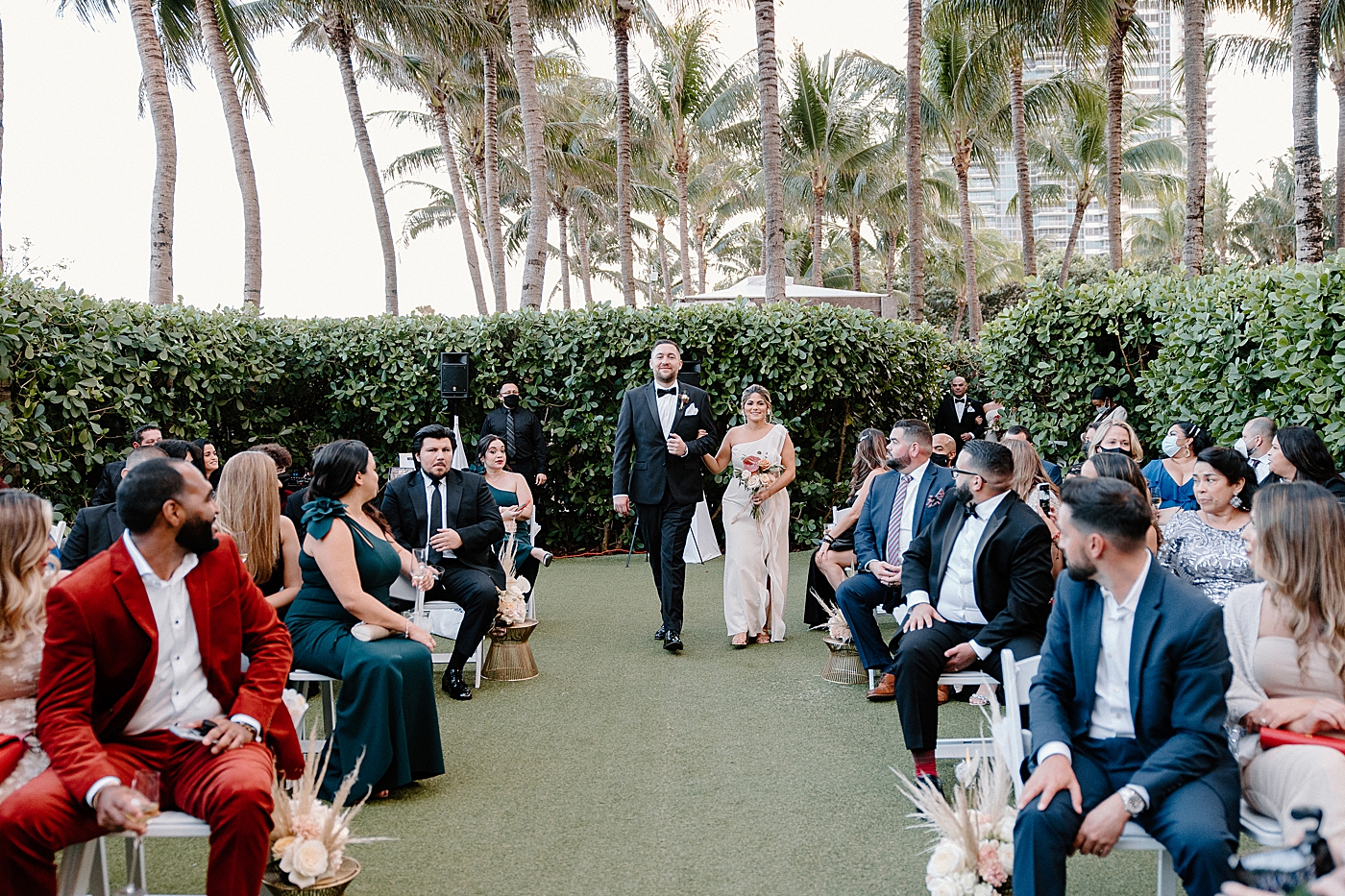 Groomsmen and Bridesmaid entering Ceremony with attendees watching Modern Elegant Wedding at The W South Beach captured by South Florida Wedding Photographer Erika Tuesta Photography