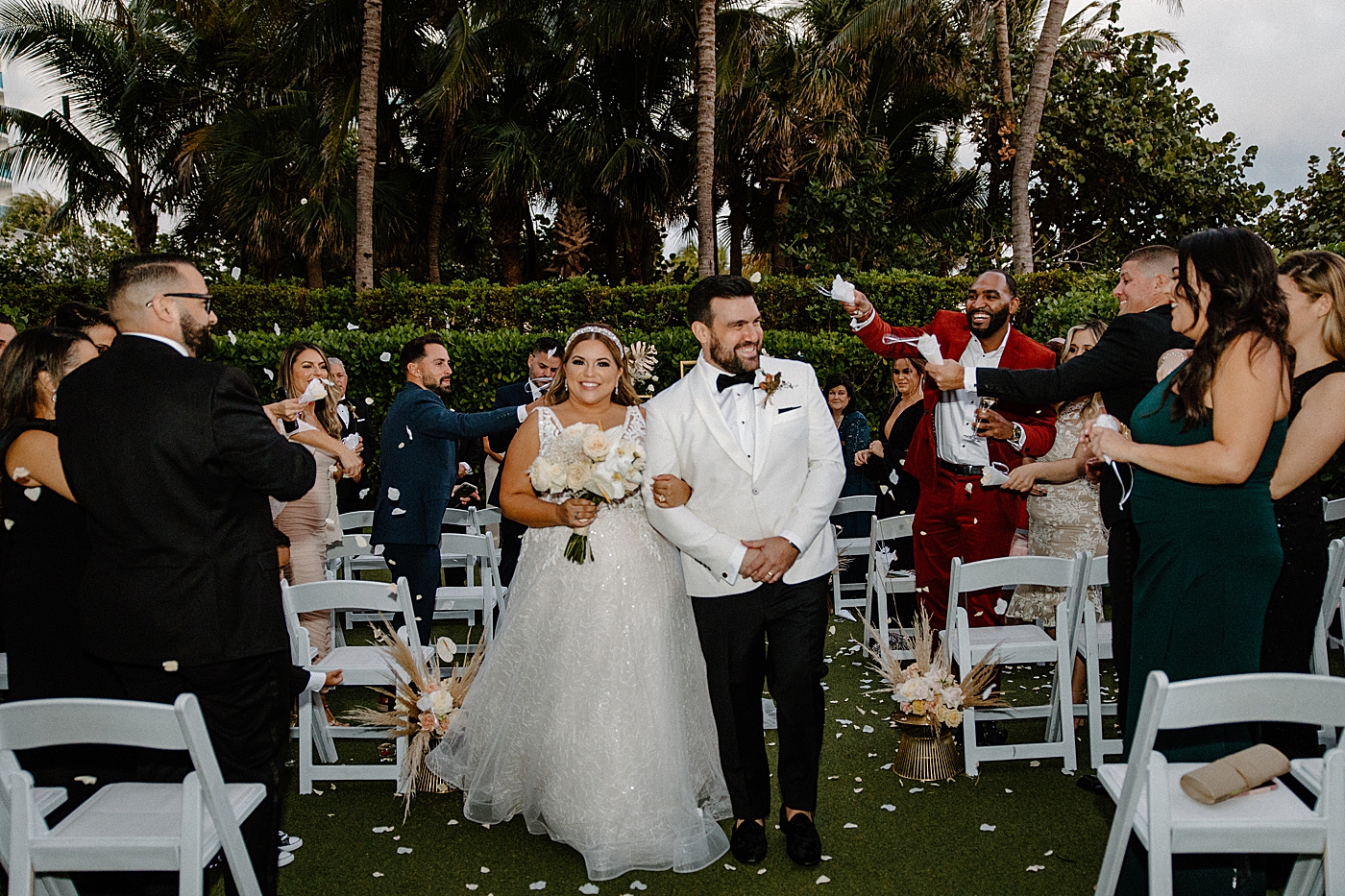 Bride and Groom exiting together with attendees throwing flower petals Modern Elegant Wedding at The W South Beach captured by South Florida Wedding Photographer Erika Tuesta Photography