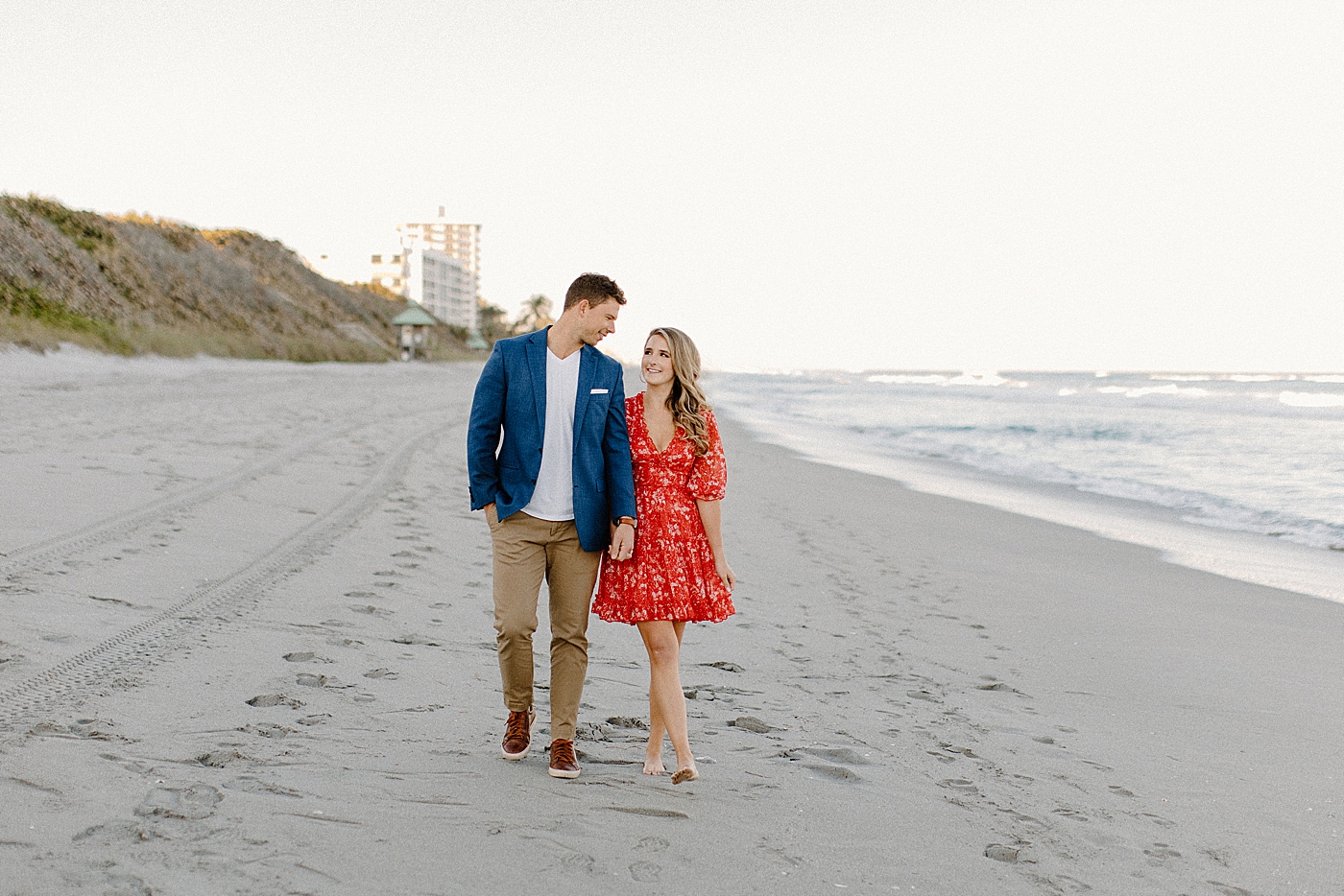 Couple walking on the sand of the beach Red Reef Park Engagement Photography captured by South Florida Engagement Photographer