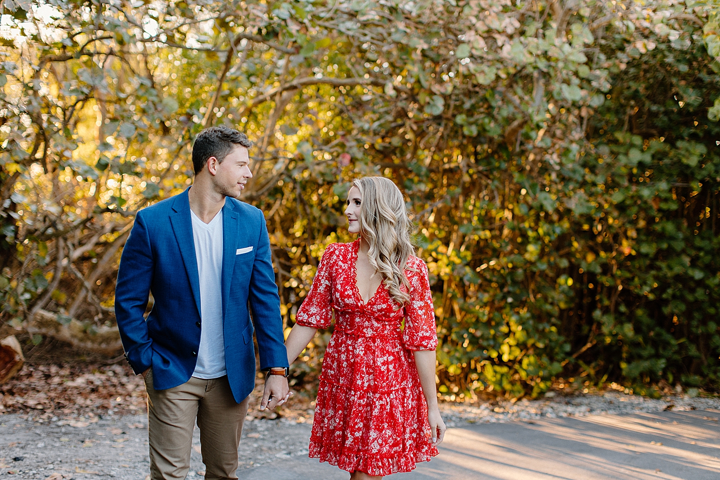 Couple holding hands looking at each other and walking together Red Reef Park Engagement Photography captured by South Florida Engagement Photographer