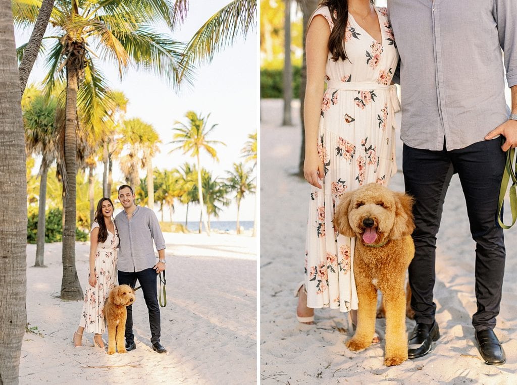 Couple holding each other with dog by their side on the sand