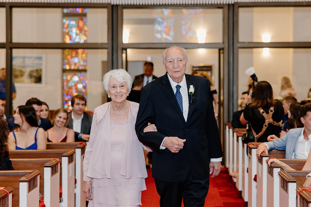 Grandparents walking arm in arm down the aisle for Ceremony