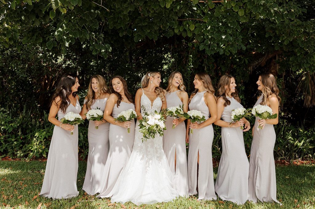 Bride with Bridesmaids out by greenery with white bouquets