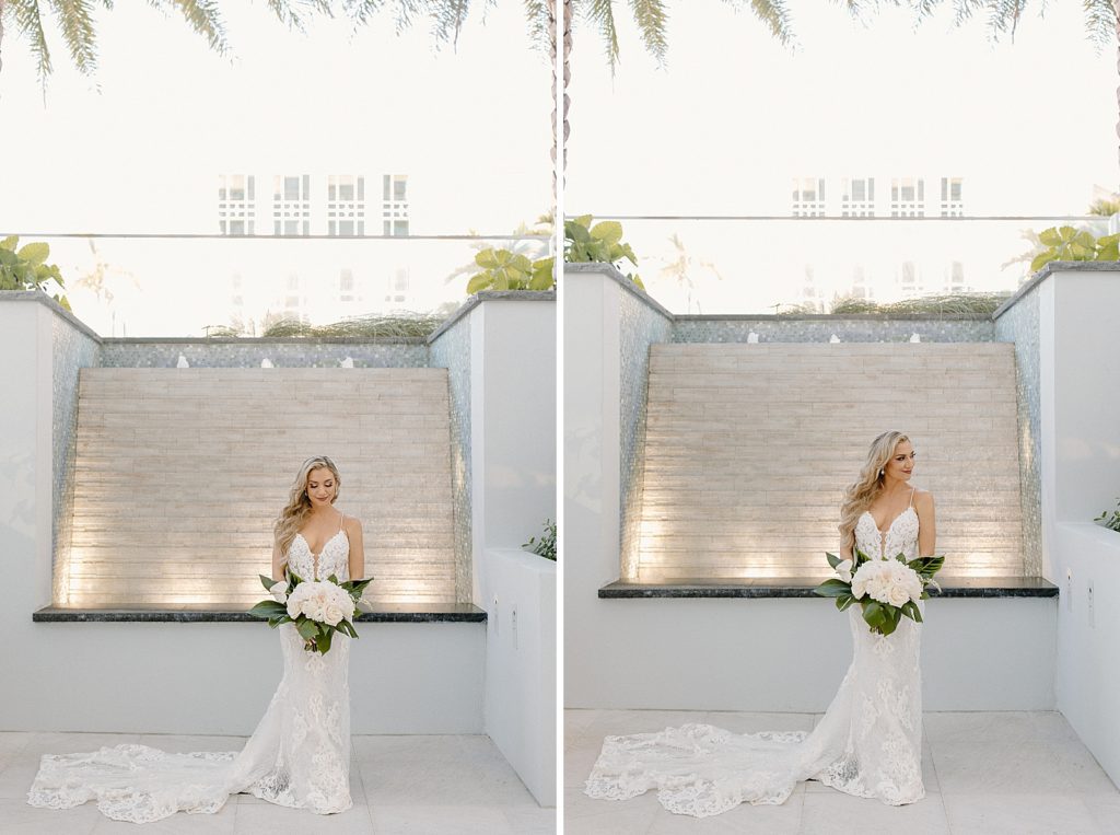 Bride with white flower bouquet in front of water fountain