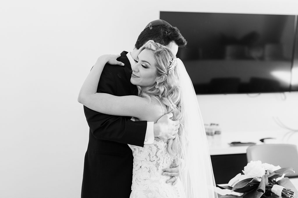 B&W Bride and groom hugging after Ceremony and signing marriage certificate