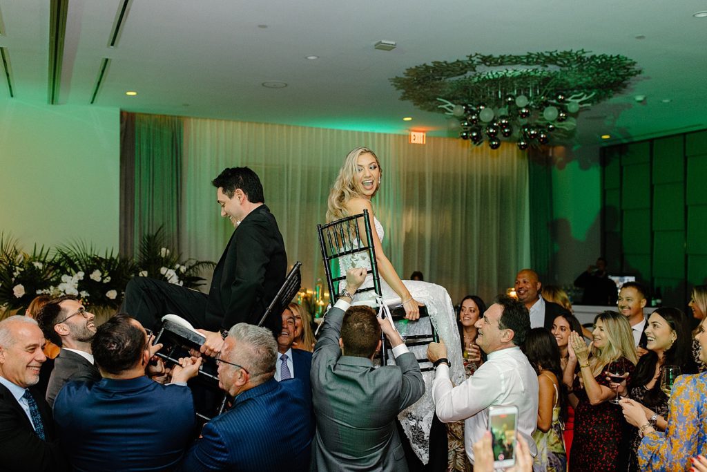 Bride and Groom sitting on chairs being lifted up in the air Jewish Tradition