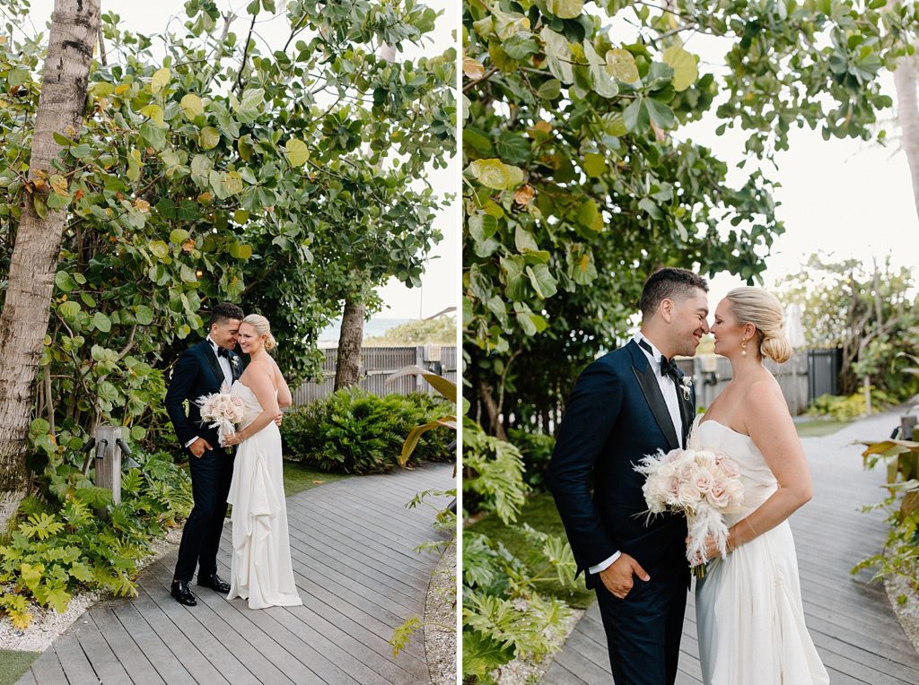 Bride and Groom nuzzling on sidewalk with greenery around them