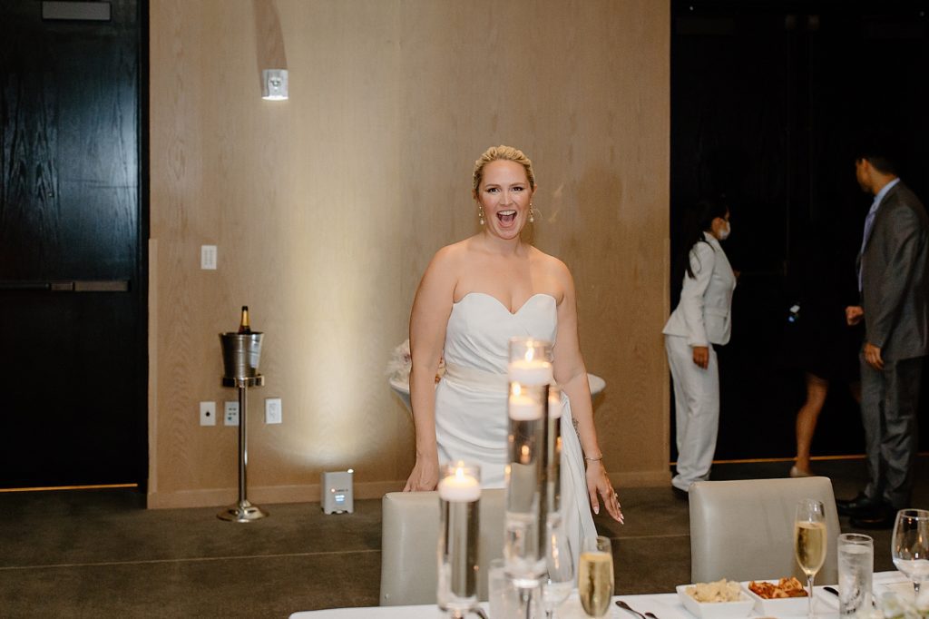 Candid shot of Bride by sweetheart table standing up
