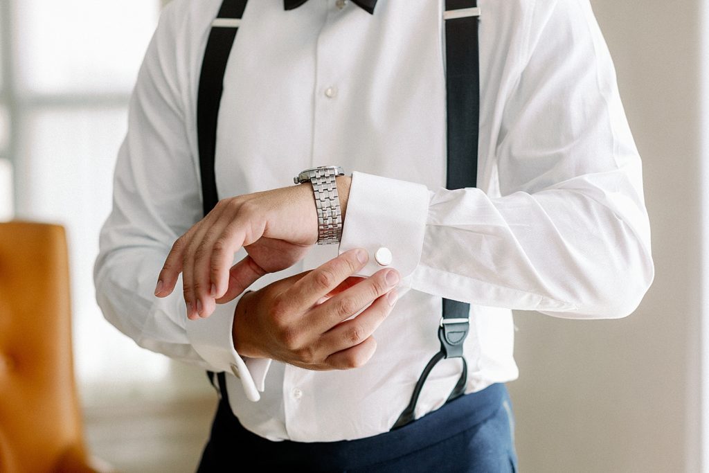 Closeup of Groom buttoning cuff getting ready