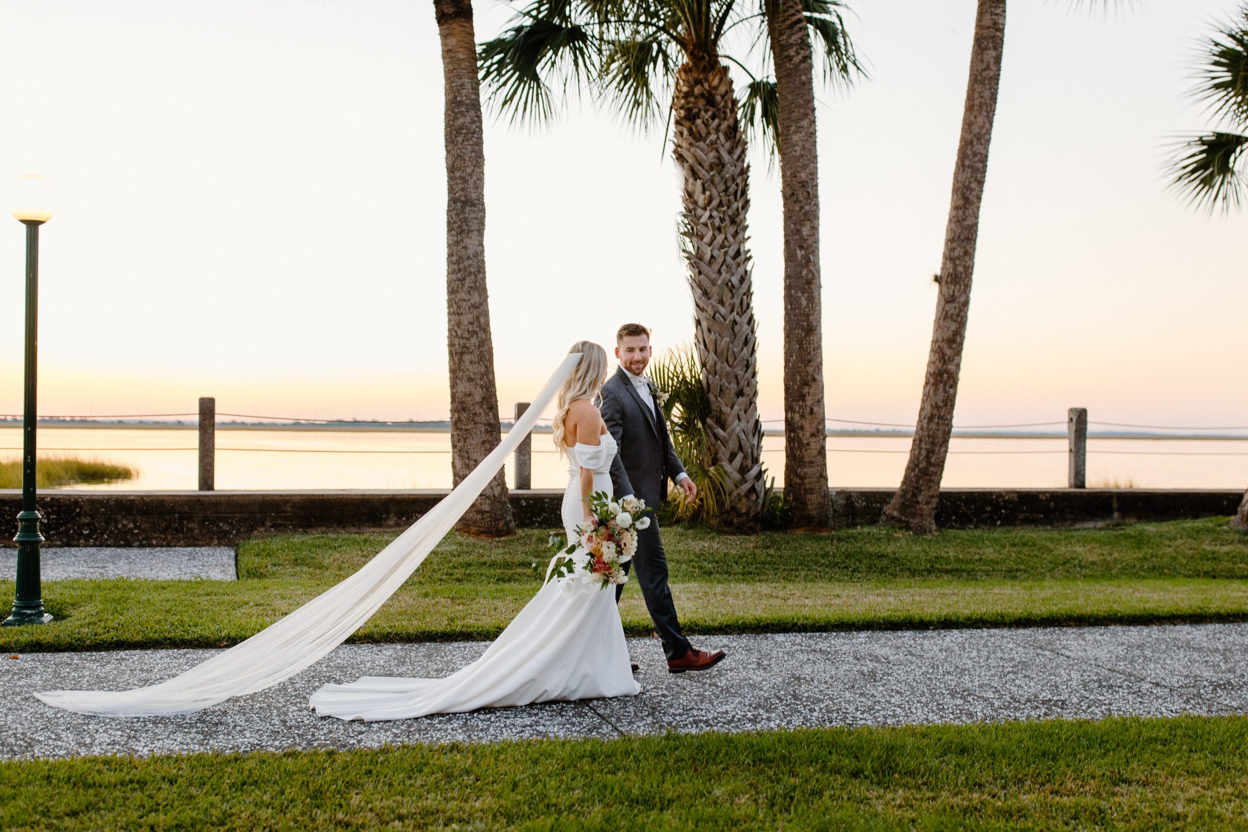 bride and groom walking at sunset