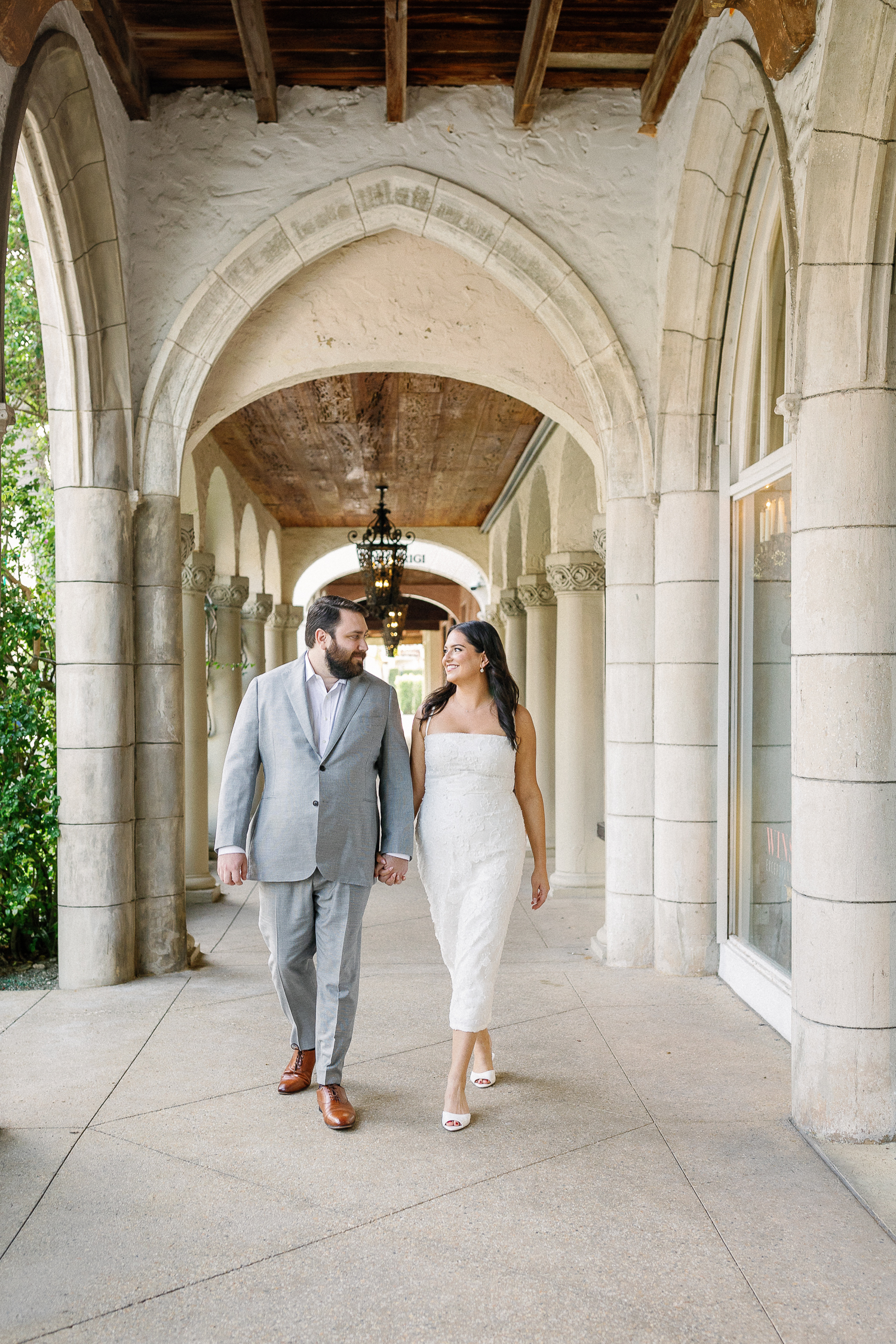 couple walking holding hads for their west palm beach engagement photos in worth avenue 